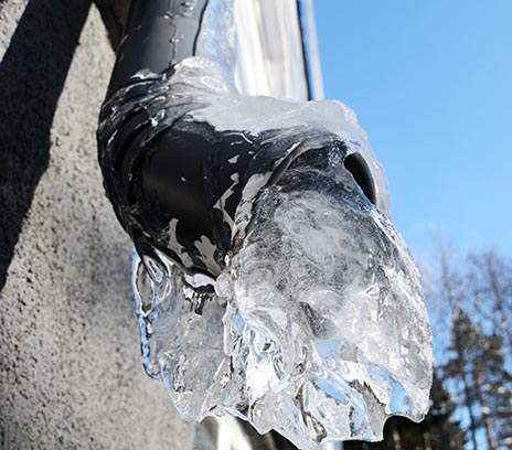 Outdoor pipe with ice coming out of the opening