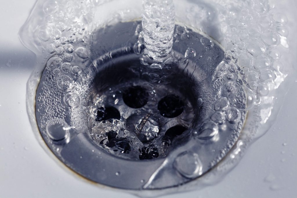 Close up of water running down drain