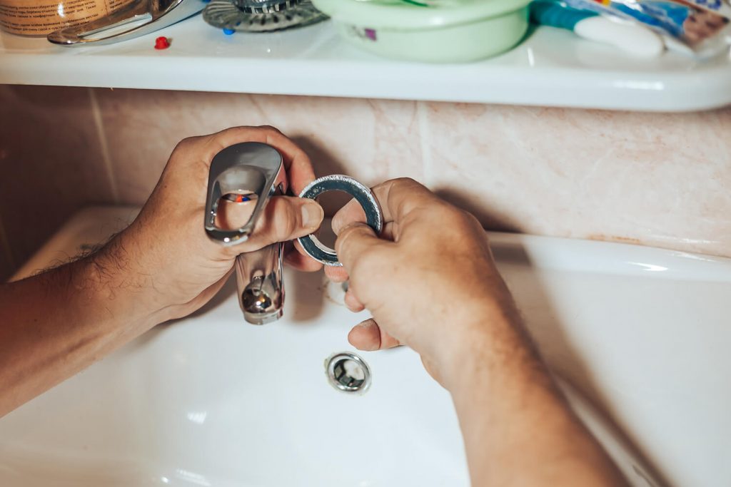 Person fixing a dripping faucet